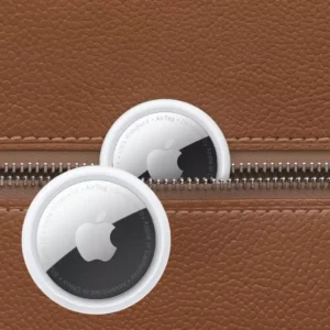 White Apple AirTag with its polished steel front facing the camera.